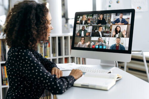 African american business woman, sits in front of a computer screen, talks via video link with international colleagues, employees, discusses a future project, perspective, business strategy, plan